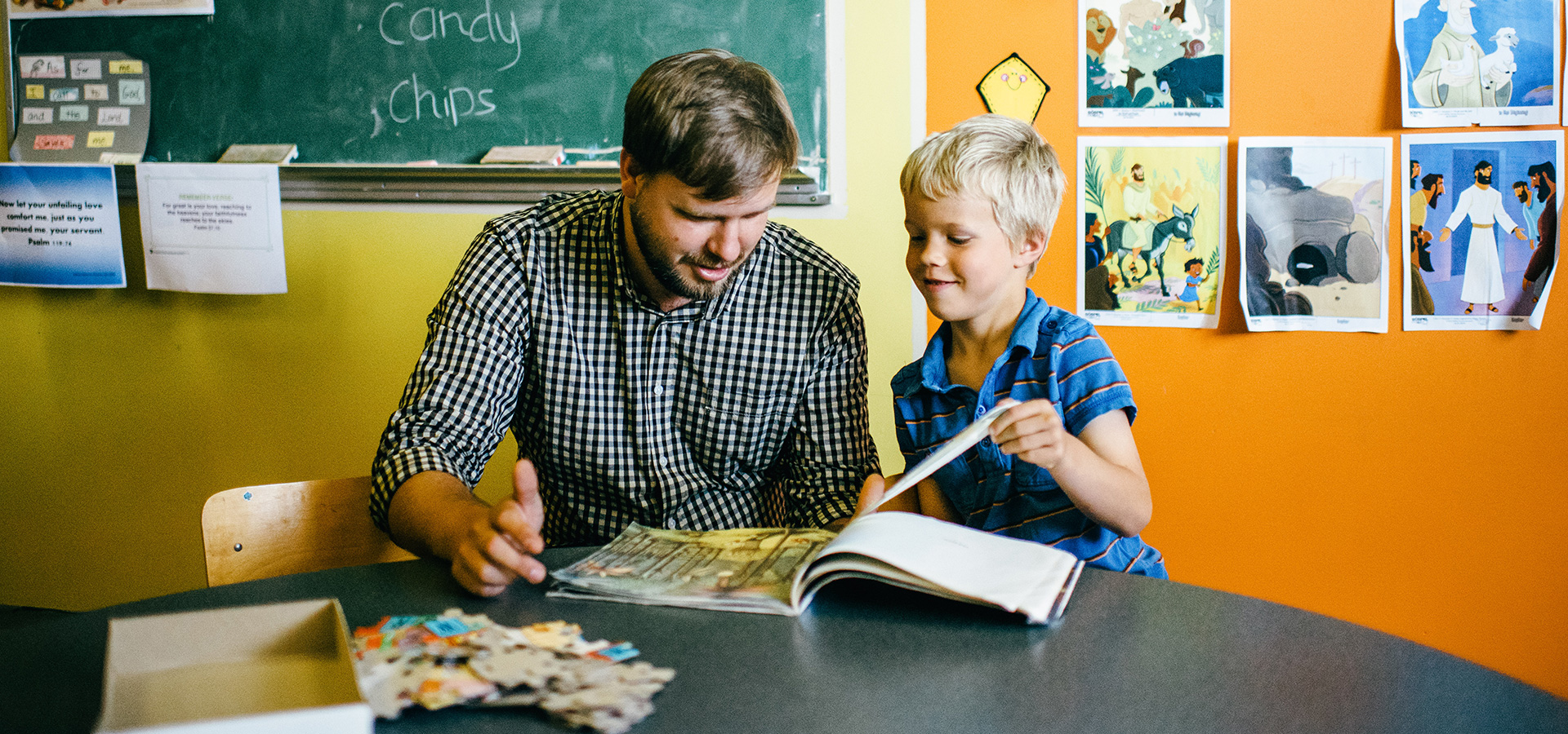 Graduate of education assistant program with child in classroom.