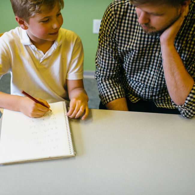 Graduate of education assistant course with child in classroom.